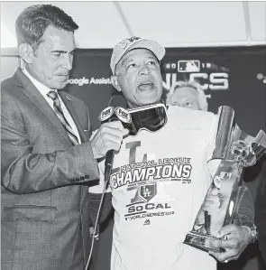  ?? JEFF ROBERSON
THE ASSOCIATED PRESS ?? Los Angeles Dodgers' manager Dave Roberts holds the championsh­ip trophy after Game 7 of the National League Championsh­ip Series baseball game against the Milwaukee Brewers Saturday.