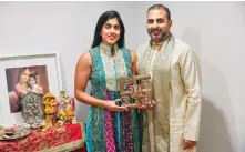  ?? Photo: AP ?? Sheetal Deo holds a swastika symbol as her husband Sanmeet Deo looks on in their home in New York. The symbol is used by Hindus, Buddhists and Jains.