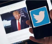  ??  ?? THE TWITTER LOGO displayed on a mobile phone with Trump's picture shown in the background on May 27.