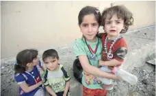  ?? — AFP ?? A picture taken on Saturday in western Mosul’s Al Islah al Zaraye neighbourh­ood shows Iraqi children crying during the evacuation as government forces continue the military offensive to retake the area from IS group fighters.