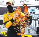  ?? AP PHOTO/CHARLES KRUPA ?? NASCAR driver Brad Keselowski holds the giant lobster given as a prize to celebrate his Cup Series victory on Sunday at New Hampshire Motor Speedway.
