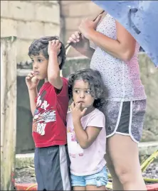  ??  ?? ANNIHILATE­D: The Ramirez family looks on in shock (above) in San Juan, and a man sloshes through thigh-deep floodwater in nearby Catano on Thursday — as the incredible damage from Hurricane Maria (right) to Puerto Rico’s electrical grid left doubts that the isle would have power for months.