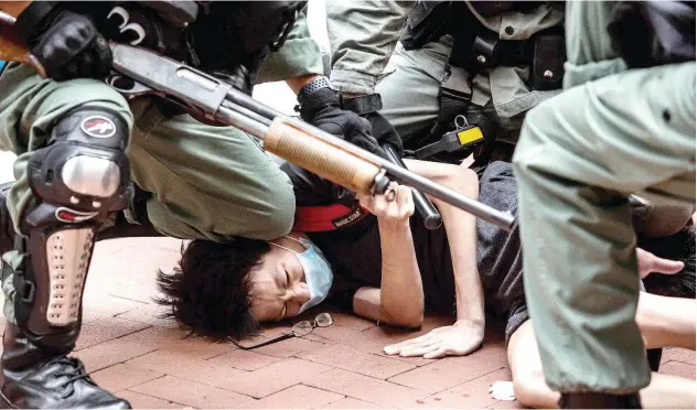  ?? Agence France-presse ?? ↑
Police arrest a pro-democracy protester in the Causeway Bay district of Hong Kong on Sunday.