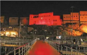  ?? ?? Warm welcome: A man walking along a path near the Erbil citadel adorned with projected Turkyish national flag colours ahead of Erdogan’s visit to Arbil. — AFP