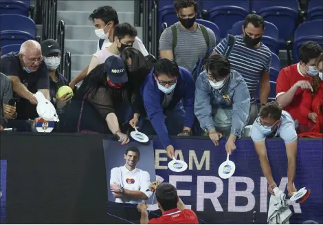  ??  ?? Novak Djokovic signs autographs after defeating Germany’s Alexander Zverev in their ATP Cup match on Feb. 5in Melbourne, Australia.