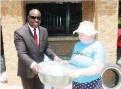  ?? ?? ZEC Commission­er Dr Kundai Shava (left) hands over a food hamper to Ms Anna Tarata in Epworth yesterday. — Picture: Nicholas Bakili