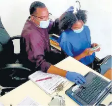  ?? TIFFANY TAYLOR PHOTOS ?? Karl Raymond utilising odern technology to analyze a patient’s scalp.