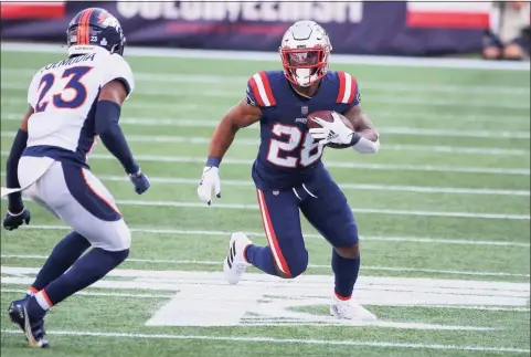  ?? Stew Milne / Associated Press ?? New England Patriots running back James White (28) runs as Denver Broncos cornerback Michael Ojemudia defends on the play during the second half on Sunday in Foxborough, Mass.