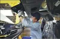  ?? ZHOU MU / XINHUA ?? A Chery Holding Group employee installs parts in a vehicle at the company’s plant in Wuhu, Anhui province.