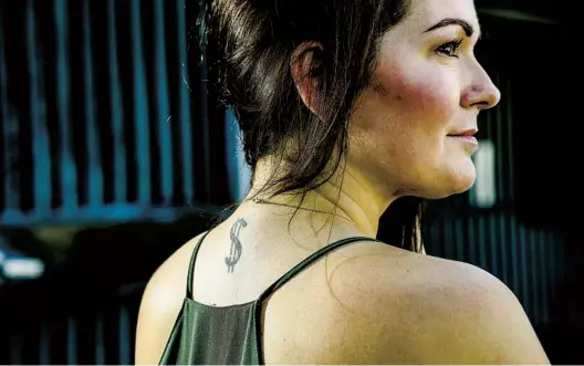  ?? EDUARDO CONTRERAS U-T PHOTOS ?? Stefanie Benvenuto displays the $ tattoo on the back of her neck — which no collar can fully cover — while posing for photos Friday along Olive Street in San Diego.