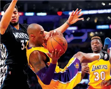  ?? ASSOCAITED PRESS ?? Los Angeles Lakers forward Kobe Bryant, center, comes down with a rebound while under pressure from Minnesota Timberwolv­es center Karl-Anthony Towns, left, and forward Julius Randle watches during the second half of an NBA basketball game in Los...