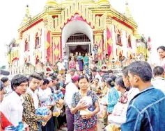  ??  ?? Flood victims receive relief goods at a temple compound.