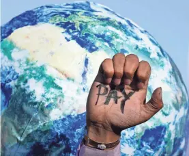  ?? PETER DEJONG/ AP ?? A hand reads “pay,” calling for reparation­s for loss and damage at the COP27 U.N. Climate Summit on Friday in Sharm el-Sheikh, Egypt.