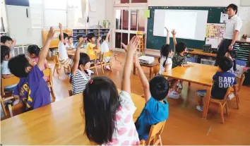  ?? AP ?? Children raise their hands to share views as they take part in a digital programme at a Coby Preschool in Yoshikawa, suburban Tokyo.