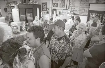  ?? Marie D. De Jesús / Houston Chronicle ?? Customers make a line inside the Tortilleri­a Tlaxcali buying tortillas Monday while also sheltering from Harvey’s rain. Many restaurant­s faced supply challenges, hindered by flooding and lack of inventory.