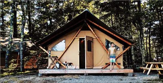  ??  ?? Griffin Goldman takes in his surroundin­gs at Huttopia, a “glamping” (glamorous camping) resort in Albany, N.H.