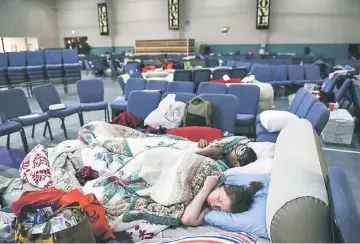  ??  ?? Hurricane Harvey evacuees Stephanie and Ubale sleep for the night at Calvary Community Church in Houston. The couple lost their home to flooding the same week they had a funeral for their newborn twins. “We lost everything and more,” they said. The...