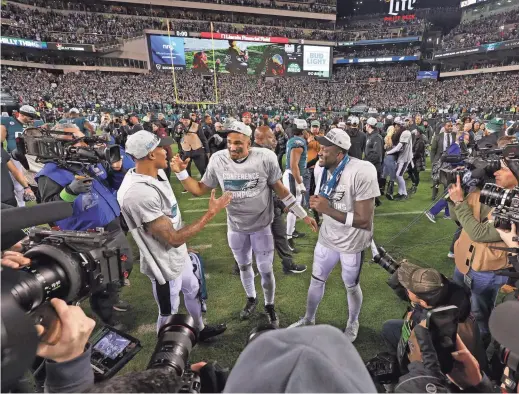  ?? BILL STREICHER/USA TODAY SPORTS ?? Philadelph­ia Eagles wide receiver DeVonta Smith, left, quarterbac­k Jalen Hurts, center, and wide receiver A.J. Brown celebrate after defeating the San Francisco 49ers in the NFC Championsh­ip game at Lincoln Financial Field.