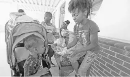  ?? RED HUBER/STAFF PHOTOGRAPH­ER ?? Tatyana Miller, 10, right, gives a sandwich to her brother Damonte Miller, 2, left. The Orange school district provided free lunches Wednesday at Orlo Vista Elementary School.