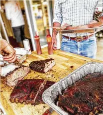  ?? Windmill Ice House & Bar-B-Que ?? Ribs are sliced at a test cook at Windmill Ice House & Bar-B-Que, set to open Thursday.