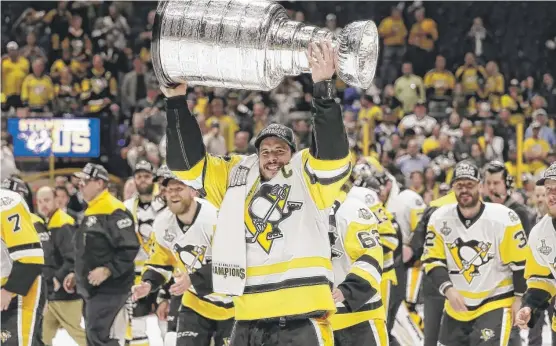  ?? | MARK HUMPHREY/ AP ?? Jubilant captain Sidney Crosby shows off the Stanley Cup after the Penguins defeated the Predators in Game 6 on Sunday to defend their title.