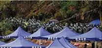  ?? Ng Han Guan / Associated Press ?? Rescue workers line up Thursday at a command center near the China Eastern crash site. One of the jet’s black boxes has been recovered in the crash that killed 132 people.