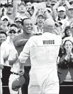  ?? DAVID CANNON/GETTY ?? Tiger Woods celebrates with caddie Joe LaCava after winning the Masters.