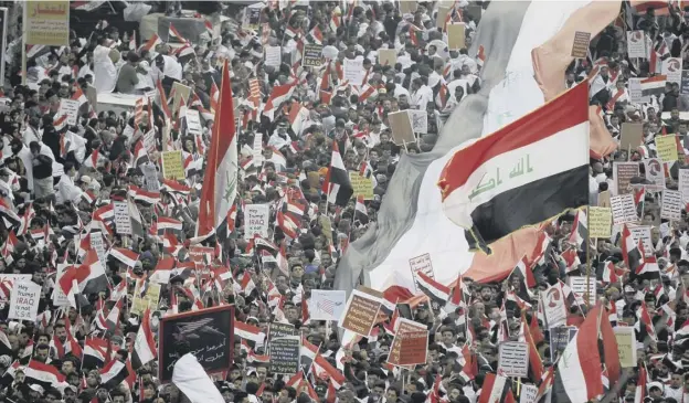  ?? PICTURE: AP ?? 0 Crowds gather at a central square in Baghdad as loudspeake­rs blasted out ‘No, no America’