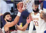  ?? MARK J. TERRILL/ASSOCIATED PRESS ?? Denver guard Jamal Murray sails in for a layup as Los Angeles’ LeBron James can only look on.