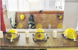  ?? Picture: Refilwe Modise ?? GOODBYE. EMS helmets and candles at the Fairview fire station in memory of the three dead firefighte­rs on Wednesday.