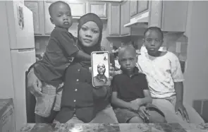  ?? DORAL CHENOWETH/COLUMBUS DISPATCH ?? Surrounded by their three children, Vatimou Mikaill has a Facetime conversati­on with her husband, Abdoulaye Lam, from Mauritania, who was deported in 2018 and now lives in Senegal. The children are, from left, Mouhamed, 3; Abdoulahi, 7; and Aminatou, 8. Local groups are working with organizati­ons across the nation to urge the Biden administra­tion to bring back immigrants who were unfairly deported during the Trump administra­tion.