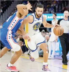  ?? — AFP photo ?? Currylooks to drive past Jaden Springer of the Sixers.