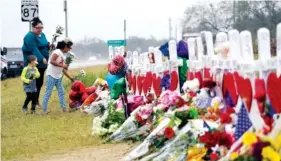  ?? THE ASSOCIATED PRESS ?? Christina Osborn and her children Alexander Osborn and Bella Araiza visit a makeshift memorial for the victims of the shooting at Sutherland Springs Baptist Church on Sunday in Sutherland Springs, Texas.