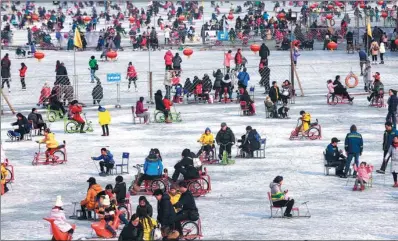  ?? ZOU HONG / CHINA DAILY ?? Tourists enjoy themselves at the Shichahai skating rink in Beijing on Friday, the first working day after the Spring Festival holiday.