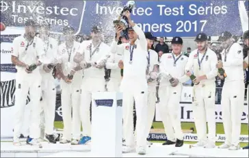  ?? GLYN KIRK/AFP ?? England captain Joe Root lifts the Test series trophy as players celebrate victory on the third day of the third Test against West Indies at Lord’s cricket ground in London on Saturday.