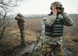  ?? YASUYOSHI CHIBA/GETTY-AFP ?? Ukrainian servicemen cover their ears as they fire a mortar round toward a Russian position near the front line Tuesday in the country’s Donetsk region.