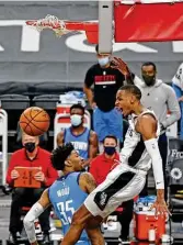  ?? Ronald Cortes / Contributo­r ?? Dejounte Murray lets out a yell after dunking on Rockets center Christian Wood.