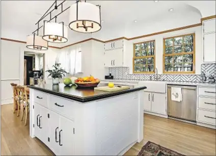  ??  ?? THE FOUR SQUARE-style Mediterran­ean home features a kitchen with updated tile work.