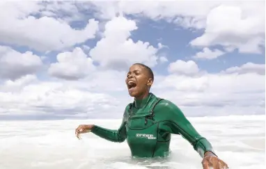  ?? PICTURES: EPA-EFE ?? THAT’S THE WAY: Junior mentor Fundiswa Feke, 20, excitedly encourages a student to stand up for the first time while learning to surf during a Waves For Change therapy session at Surfers Corner in Muizenberg.