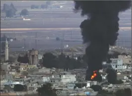  ?? The Associated Press ?? SYRIA: Flames and smoke billow from a big fire in Ras al-Ayn, Syria, caused by bombardmen­t by Turkish forces on Wednesday. Turkey's President Recep Tayyip Erdogan called Wednesday on Syrian Kurdish fighters to leave a designated border area in northeast Syria 'as of tonight' for Turkey to stop its military offensive.