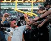  ?? ARIC CRABB — BAY AREA NEWS GROUP ?? Raiders head coach Jon Gruden, left, celebrates with fans after their 17-10 win over the Cincinnati Bengals on Sunday in Oakland.