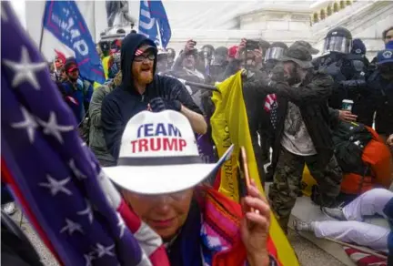  ?? JOHN MINCHILLO/AP ?? Insurrecti­ons loyal to Donald Trump tried to break through a police barrier at the Capitol in Washington on Jan. 6, 2021.