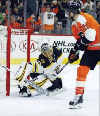  ?? TOM MIHALEK — THE ASSOCIATED PRESS ?? The Flyers’ Claude Giroux, right, scores the game-winning goal Bruins goalie Anton Khudobin Sunday in a 4-3 decision. in overtime past Boston