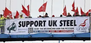  ?? ?? BRIDGE PROTEST Workers with a banner and waving flags campaignin­g against proposed job losses at the Tata Steel works in Port Talbot in South Wales