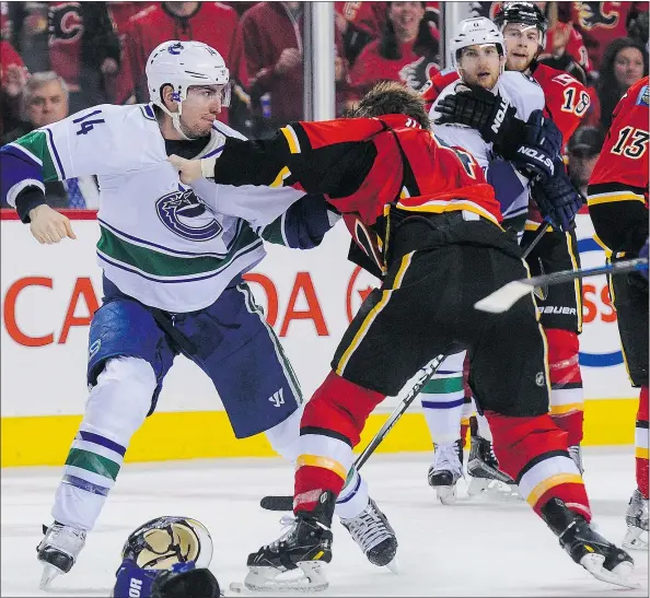  ?? — GETTY IMAGES FILES ?? Vancouver Canucks forward Alex Burrows fights Kris Russell Sunday in Calgary. Burrows received a boarding minor for a hit on Johnny Gaudreau and a game misconduct to go with the fighting major and instigator penalty, which was rescinded Monday.