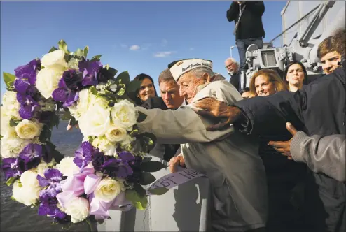  ?? Spencer Platt / Getty Images ?? Local Pearl Harbor survivor Armando “Chick” Galella, 97, throws a wreath off of the USS Intrepid at an event on Friday in New York City marking the 77th anniversar­y of the attack on Pearl Harbor. Japanese bombers attacked Pearl Harbor on Dec. 7, 1941 resulting in the deaths of 1,177 crew members on the U.S. Arizona. The attack prompted the United States to declare war on Japan and, shortly after, on Germany.