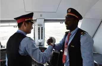  ??  ?? Chinese train driver Liu Ji and an Ethiopian counterpar­t shake hands before the inaugurati­on ceremony of the China-built Addis Ababa-Djibouti Railway in Addis Ababa, Ethiopia, on October 5, 2016