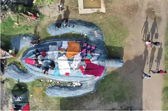  ?? ?? Aerial view of stranded migrants from Haiti at a makeshift camp in Necocli, Colombia. Thousands of migrants remain stranded in a Colombian port town as they wait for boats to cross into neighborin­g Panama on their way to the United States, a state relief agency said. — AFP photos