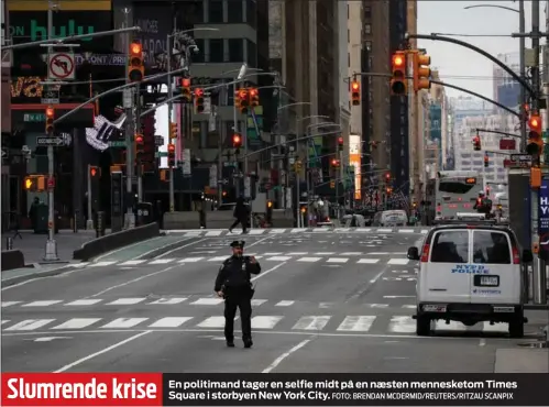  ?? FOTO: BRENDAN MCDERMID/ REUTERS/ RITZAU SCANPIX ?? Slumrende krise
En politimand tager en selfie midt på en næsten mennesketo­m Times Square i storbyen New York City.