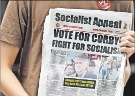  ??  ?? Demagogues of the world, unite! An activist holds a socialist paper as Labor’s hard-socialist Jeremy Corbyn arrives in north London Aug. 9.